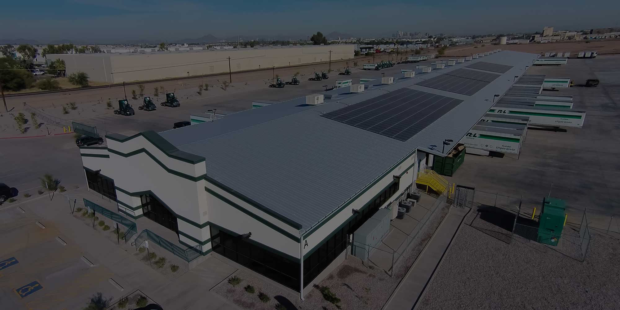 An aerial view of a storage facility with solar panels on the roof.