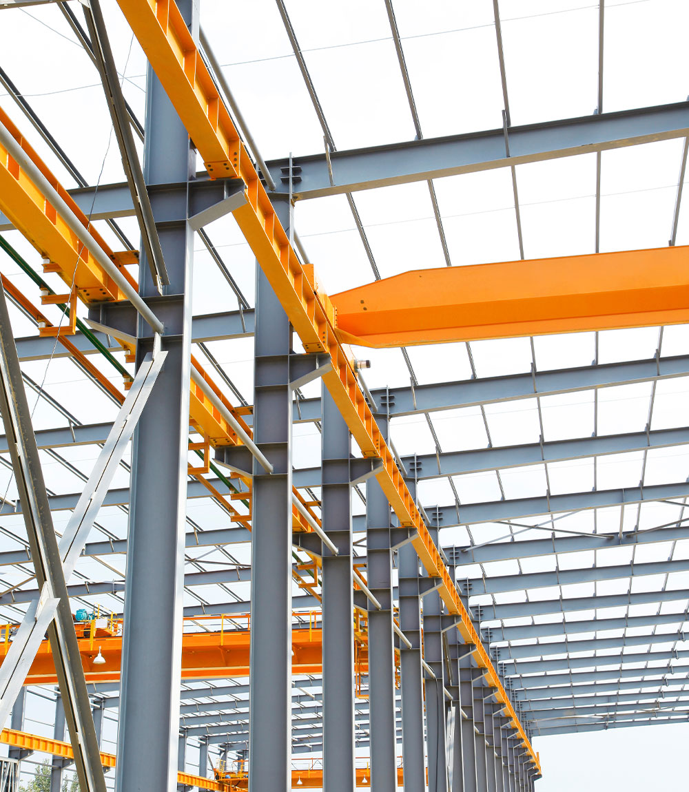 A large steel structure with orange cranes.